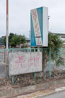 Faded "Land for Sale" sign outside abandoned car wash, Tochigi Prefecture, Japan
