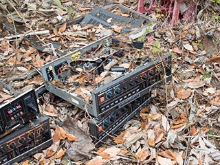Broken electronic equipment lying among fallen leaves