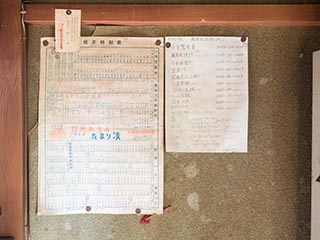 Old timetable and telephone numbers on office wall