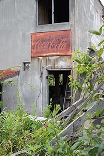 Rusty Coca Cola Sign on Abandoned Boathouse