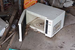 Old Microwave in Store Room of Abandoned Minshuku