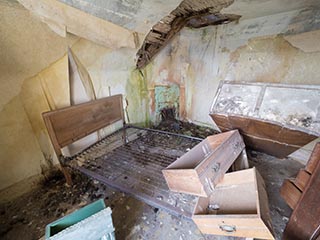 furniture jumbled in abandoned bedroom