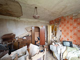 messy, water-damaged room in abandoned house