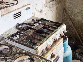 rusty gas stove in abandoned house