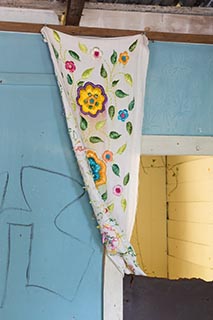 Embroidered cloth hanging on wall of abandoned house