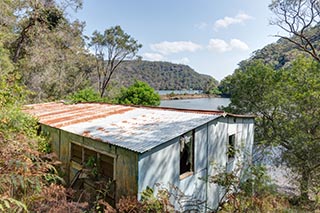 View of Mullet Creek and railway line over roof of abandoned house