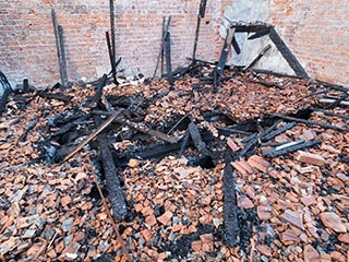 Broken roof tiles and charred timbers on floor of St. John's Orphanage