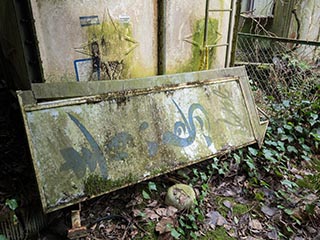 Hotel Bluebird sign lying on ground