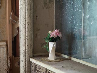 Artifial flowers behind bed