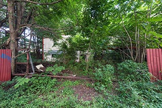 Hole in Fence of Abandoned Love Hotel Cosmo