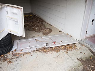 Broken door lying in carport at Hotel Penguin Village