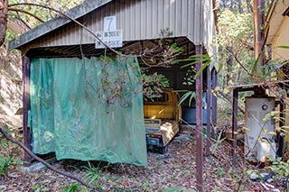 Old truck in carport of abandoned love hotel Century