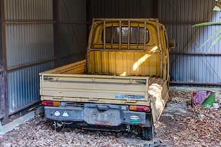 Old truck in carport of abandoned love hotel Century