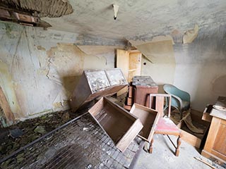 furniture jumbled in abandoned bedroom