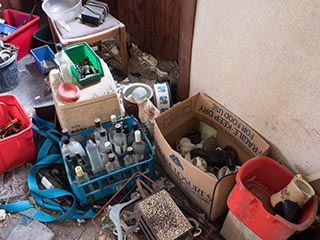 empty bottles and junk on floor of abandoned house