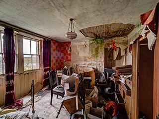 messy, water-damaged room in abandoned house