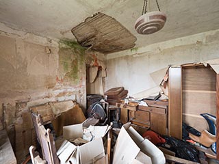 messy, water-damaged room in abandoned house