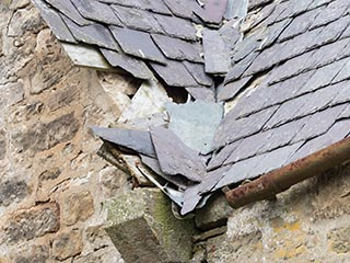 damaged slate roof of abandoned house