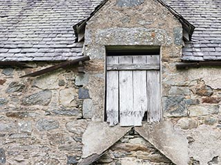 boarded window in ruined house