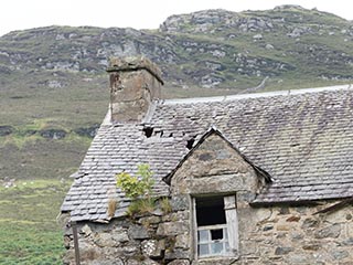 roof and broken window of ruined house